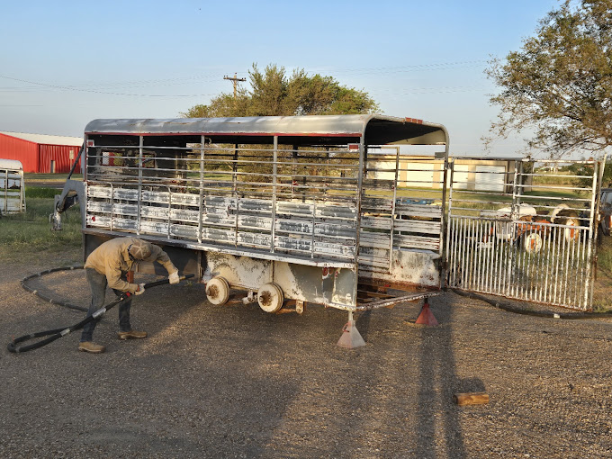 A man is working on a cattle trailer