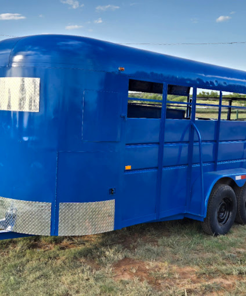 A blue horse trailer parked in a field