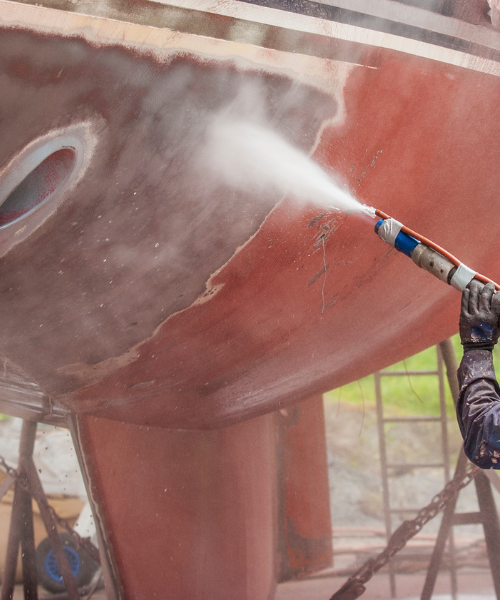 A man is spraying water on a boat